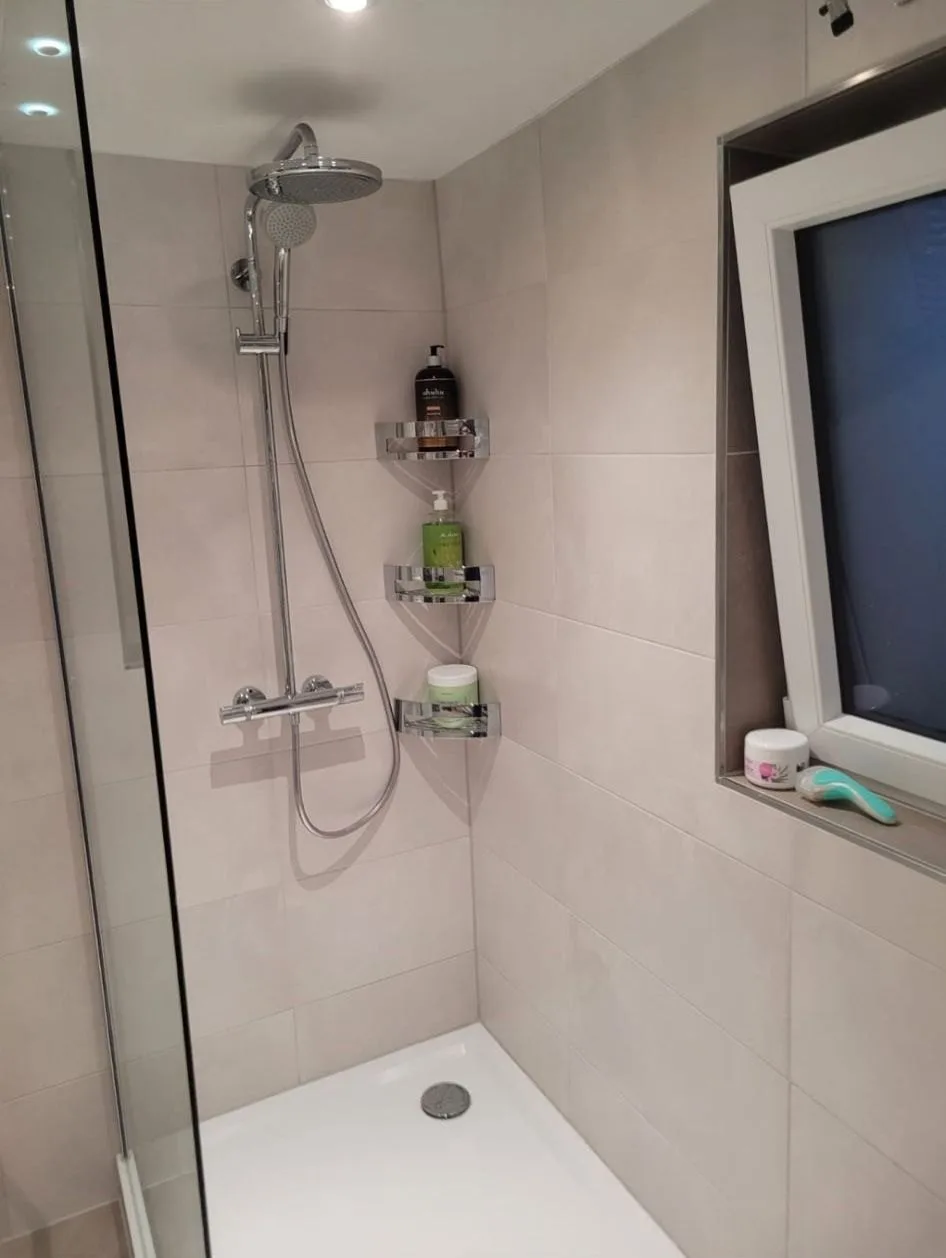 Dusche mit Regenbrause, drei Eckablagen und Fensternische